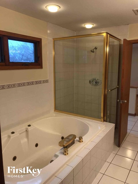 A bathroom with a white tub and a glass shower door.