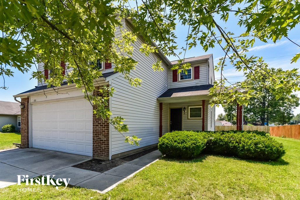a white house with a driveway and a white garage door
