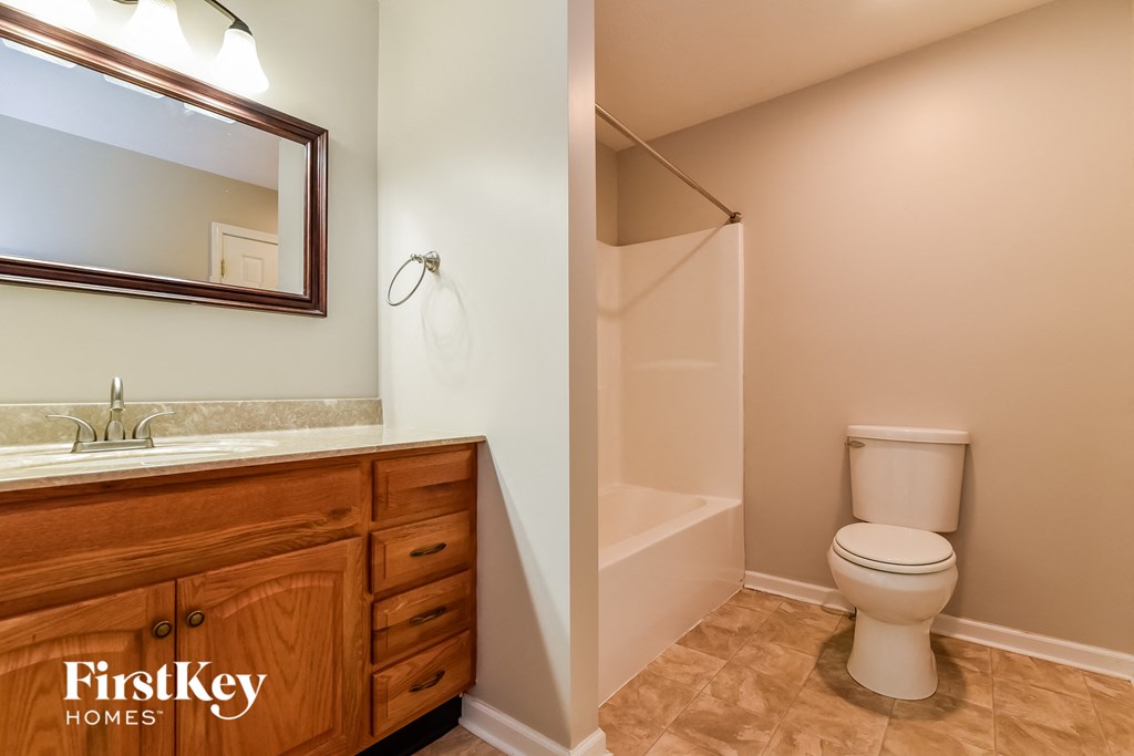 a bathroom with a toilet and a shower and a sink