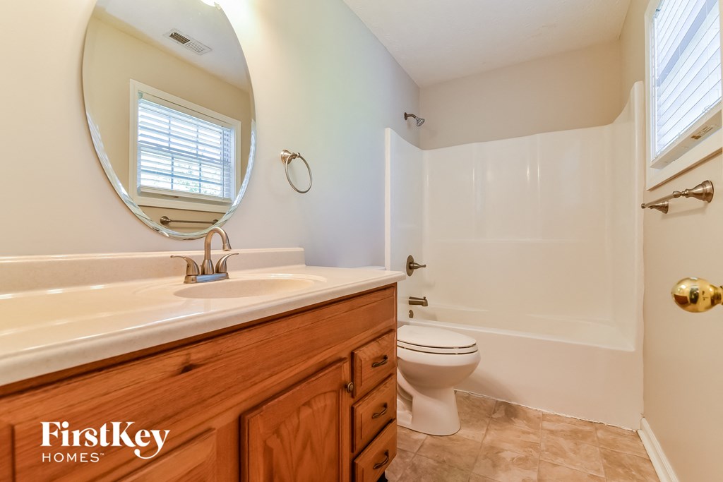 a bathroom with a toilet and a sink and a mirror