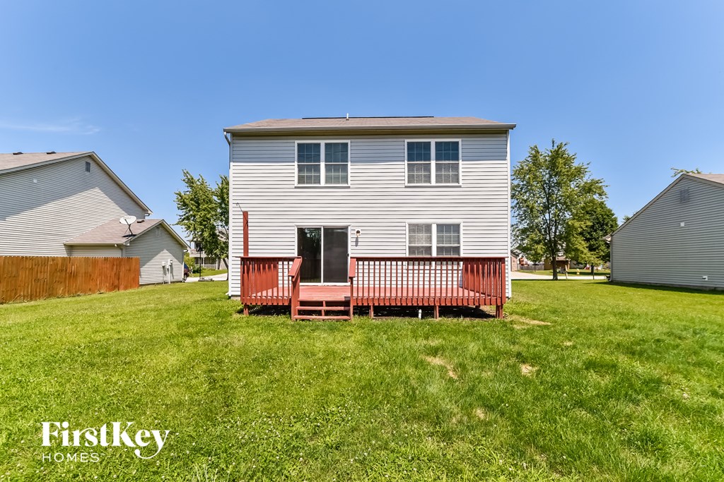 a white house with a red porch in a grassy yard