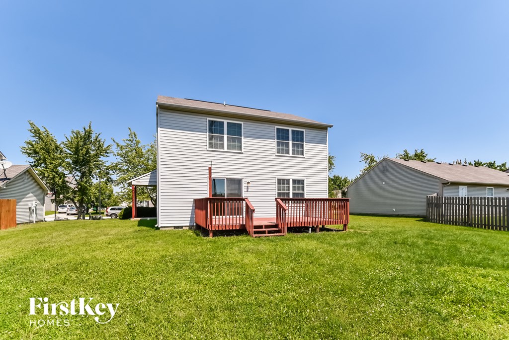 a white house with a wooden deck in a yard