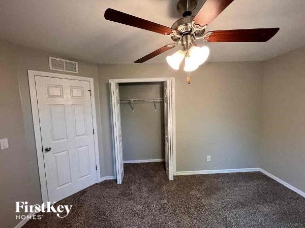 a bedroom with a ceiling fan and a closet