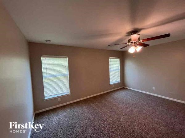 an empty living room with a ceiling fan