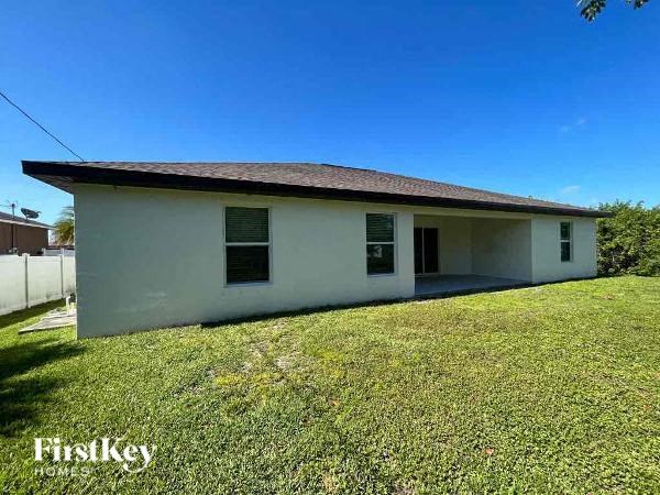 a small white house sitting in a grass field
