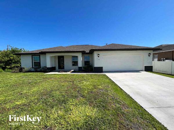 a white house with a lawn and a driveway