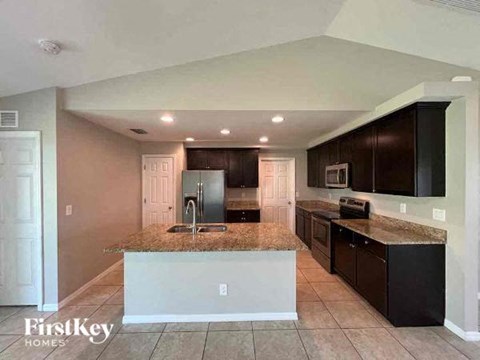 a kitchen with a granite counter top and a refrigerator