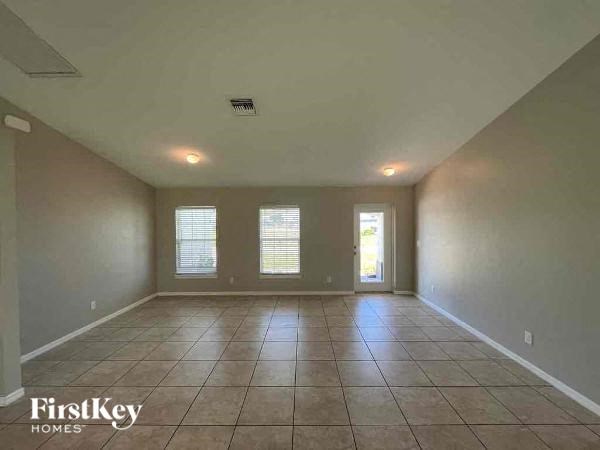 an empty living room with a tiled floor