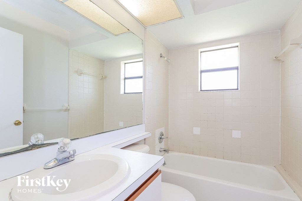 a bathroom with a sink and a tub and a mirror