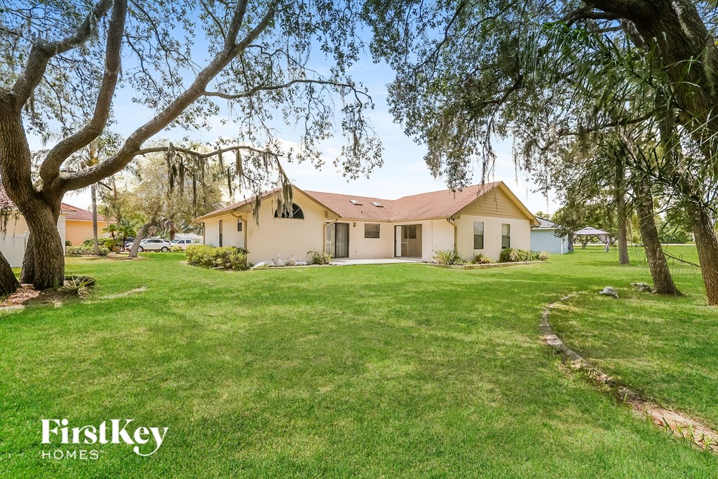a house with a lawn and trees in front of it