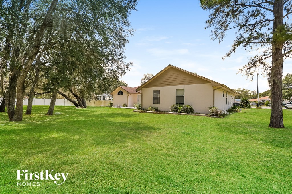 a house with a lawn and trees in front of it