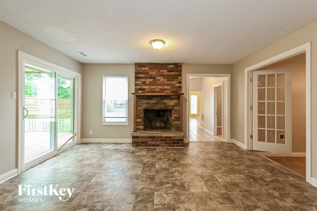 a living room with a fireplace and a door to a porch
