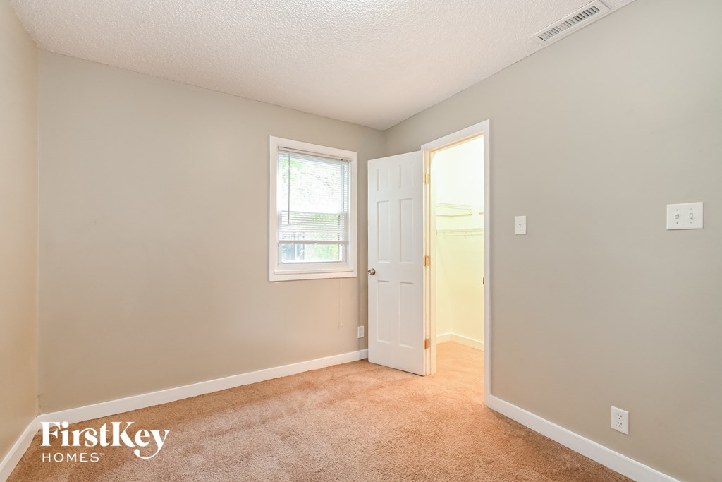 a bedroom with a door to a closet and a window