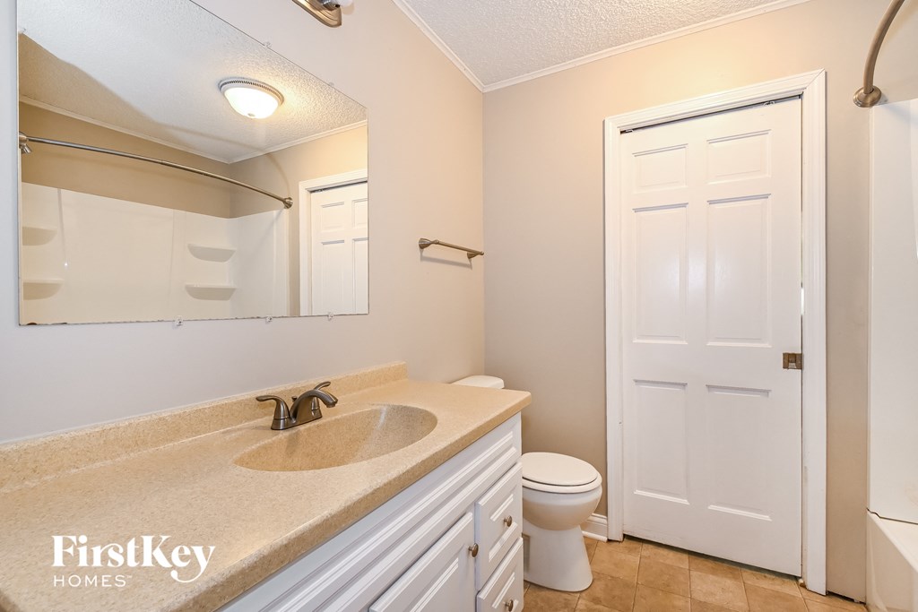 a bathroom with a toilet and a sink and a mirror
