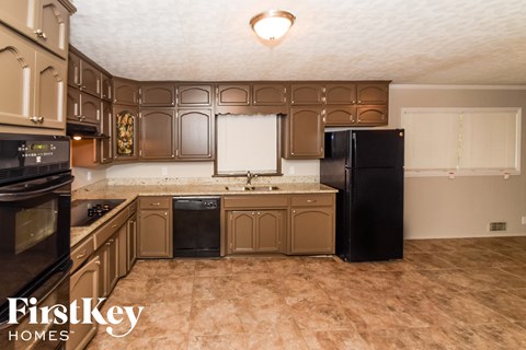 a kitchen with brown cabinets and black appliances