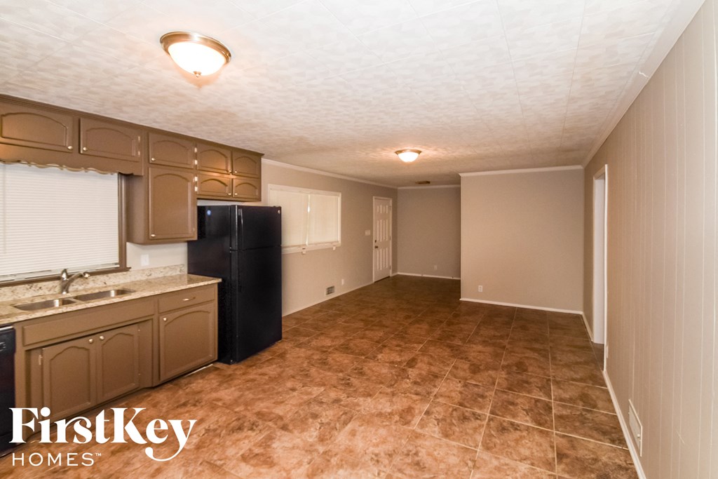 a kitchen with a sink and a refrigerator in a house