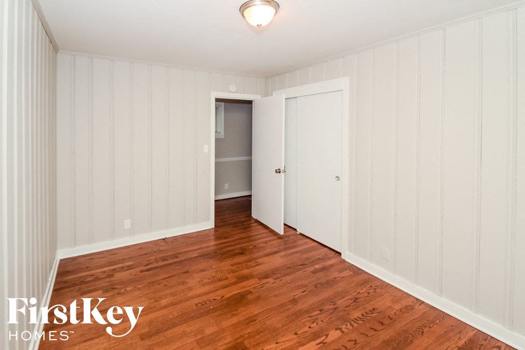 a bedroom with a hard wood floor and a door to a closet