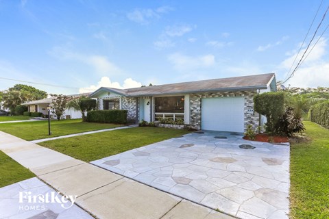 A house with a garage and a driveway in front.