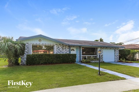 A house with a blue roof and a sign that says "FirstKey Homes".