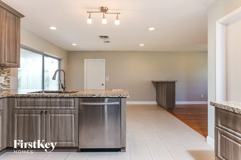 A kitchen with a stainless steel dishwasher and a granite countertop.