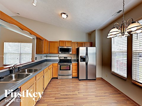 A kitchen with wooden cabinets and a stainless steel refrigerator.