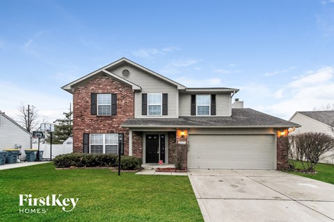 a house with a garage door and a lawn