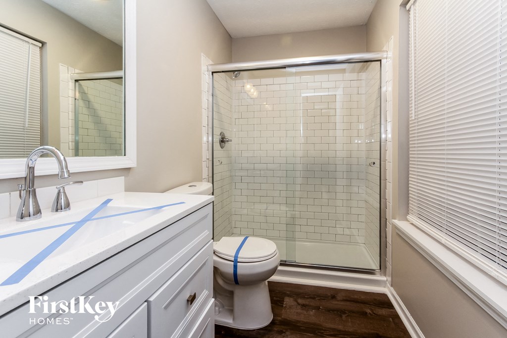 a bathroom with a shower and a sink and a toilet