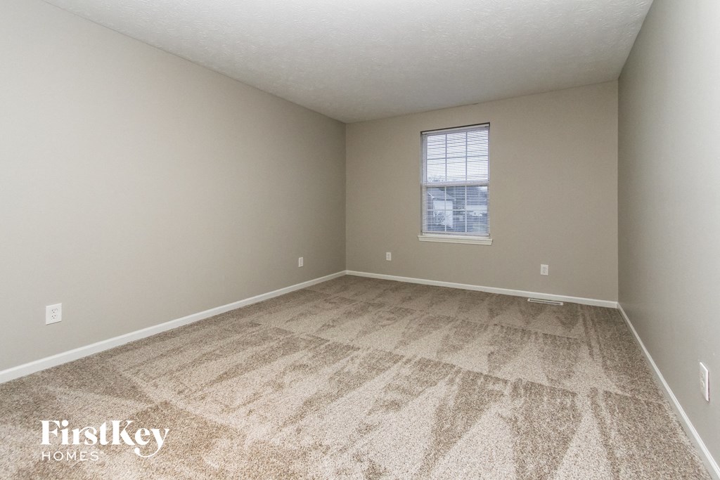 an empty room with carpet and a window