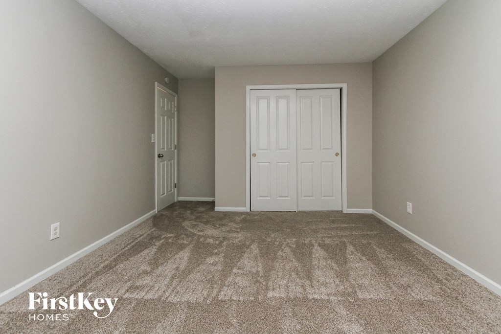 a bedroom with a carpeted floor and white doors