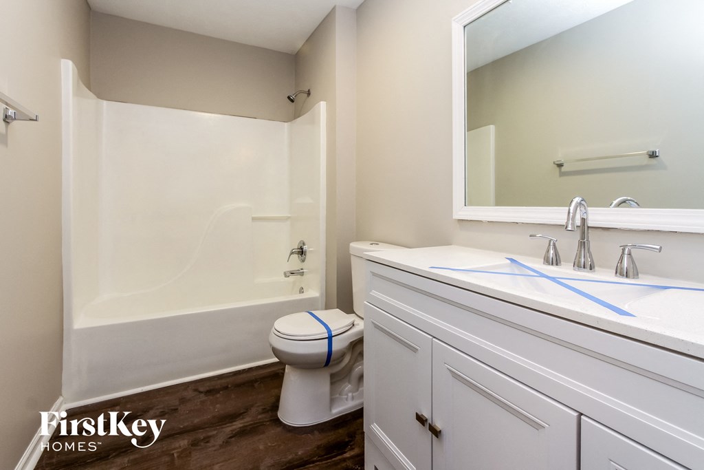 a bathroom with a toilet and a tub and a sink