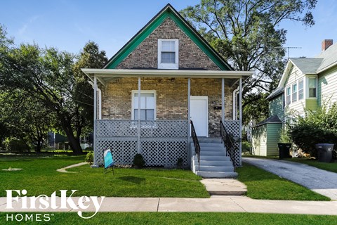 a brick house with a white lattice fence in front of it