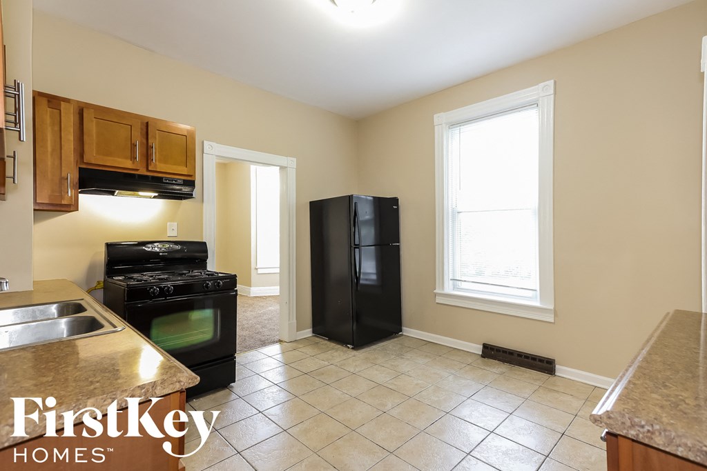 a kitchen with a black refrigerator and a sink
