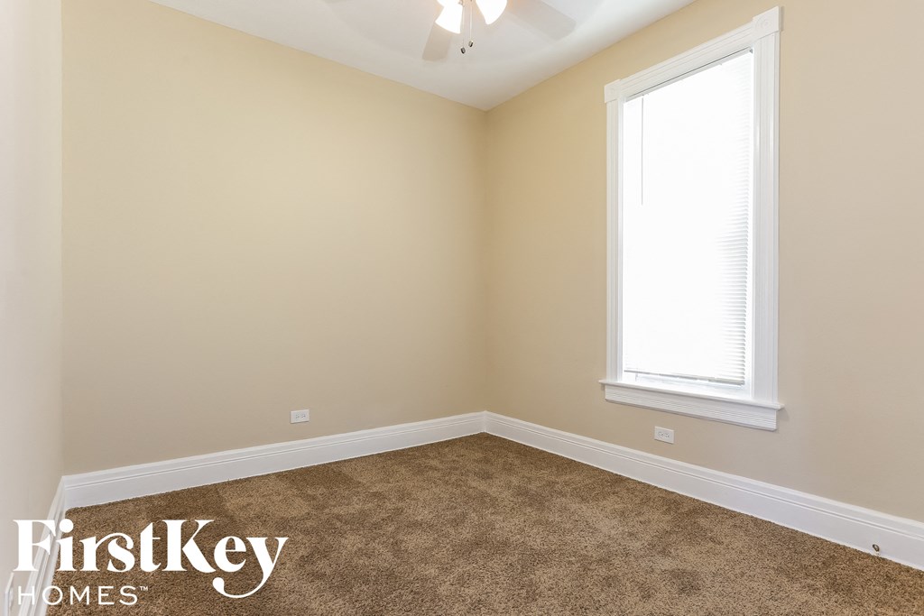 a bedroom with a carpeted floor and a window