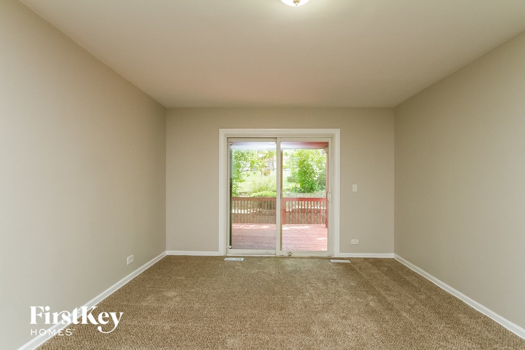 an empty living room with a door to a patio