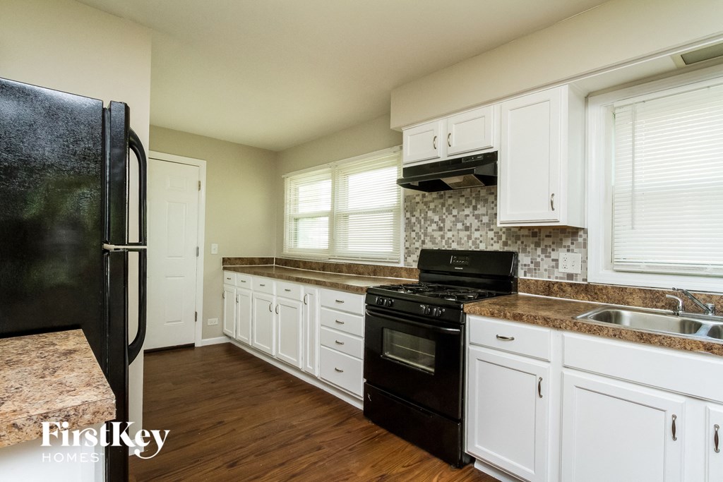 a kitchen with black appliances and white cabinets