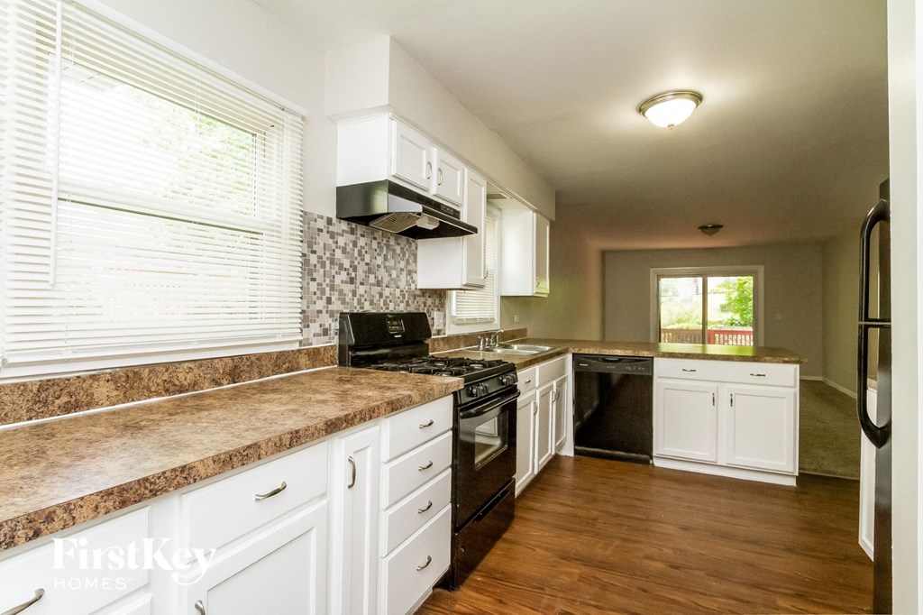 a kitchen with white cabinets and granite counter tops