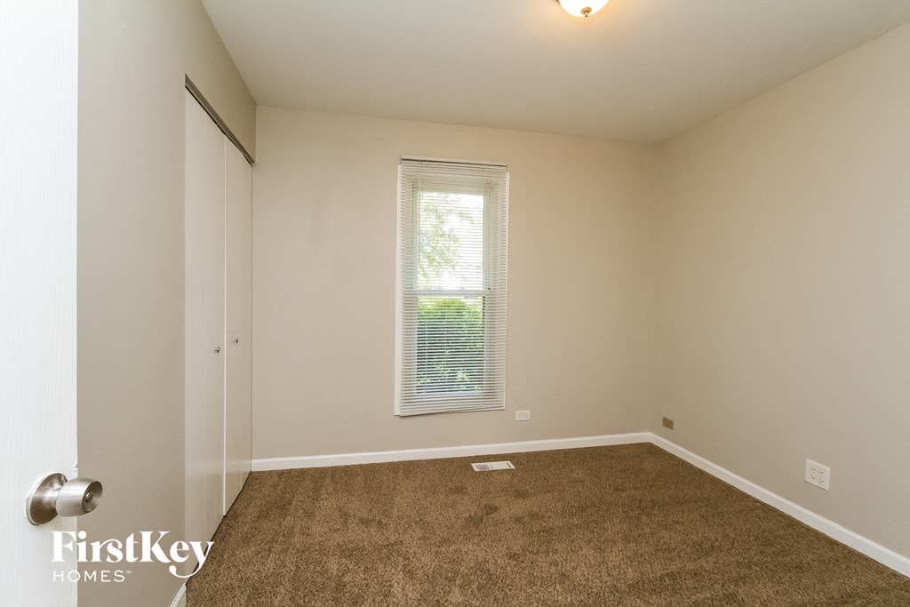 the spacious living room with carpeting and a window