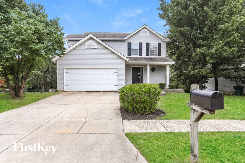a white house with a driveway and a mailbox