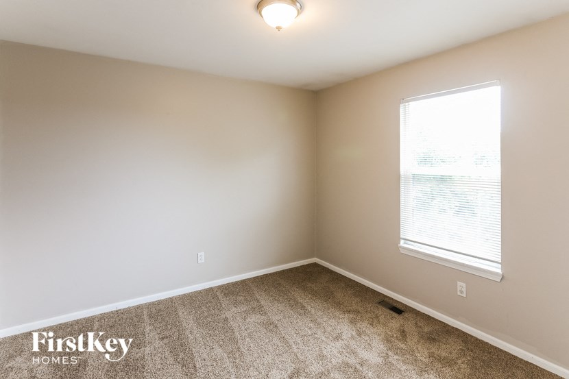an empty room with a window and carpet