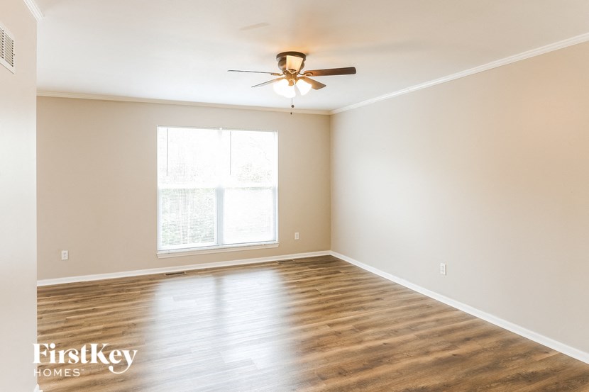 a empty room with a ceiling fan and a window