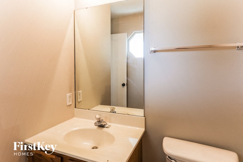 a bathroom with a toilet and a sink and a mirror