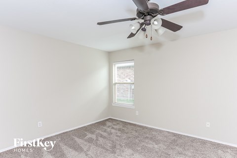 the living room has a ceiling fan and carpet