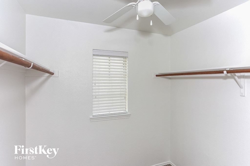 a bedroom with a ceiling fan and a closet