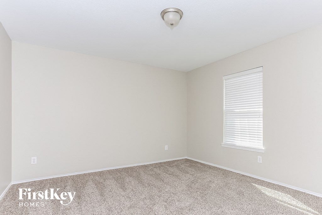 a bedroom with a carpeted floor and a window