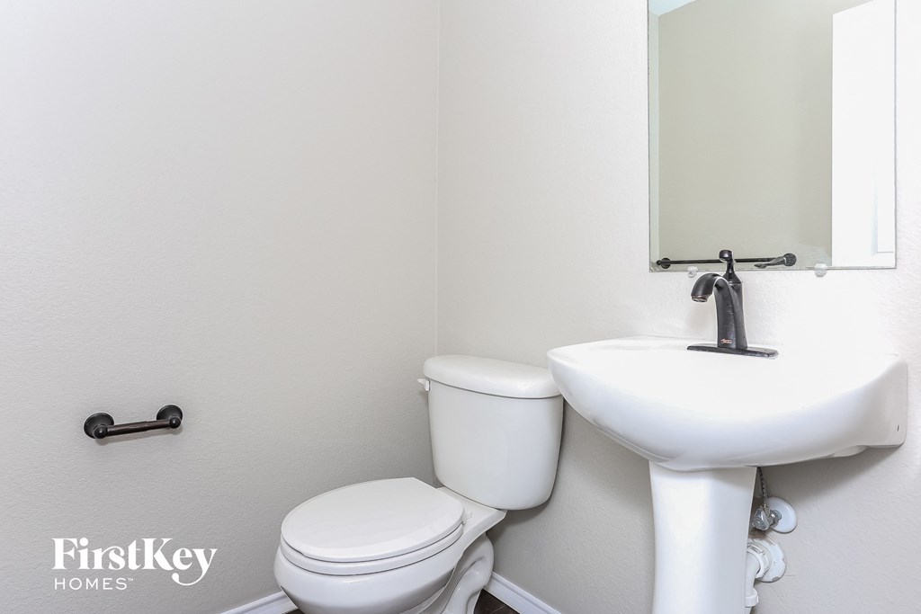 a bathroom with a toilet and a sink and a mirror