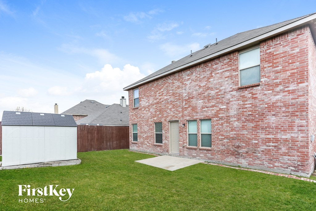 a brick house with a lawn and a fence