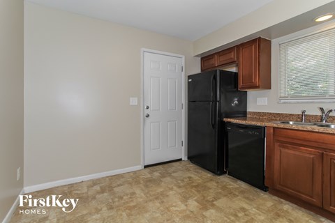 a kitchen with a black refrigerator and a sink and