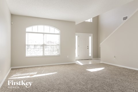a spacious living room with carpet and a large window