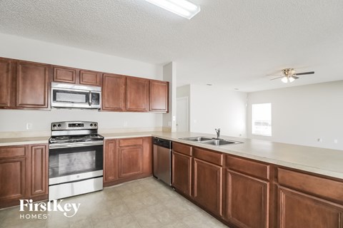 an empty kitchen with wooden cabinets and stainless steel appliances