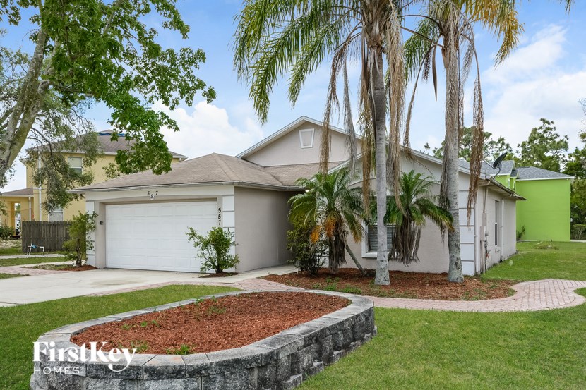 A house with a white garage door and a brick wall in front.